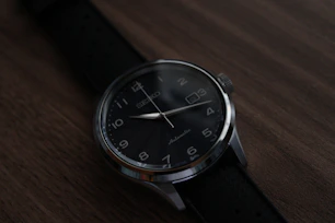 a black watch on a leather surface