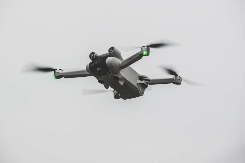 Consumer drone in flight against a bright sky