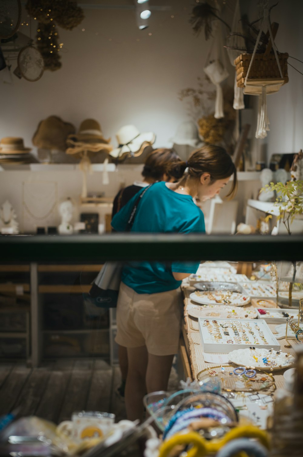 a couple of people looking at a display of hats