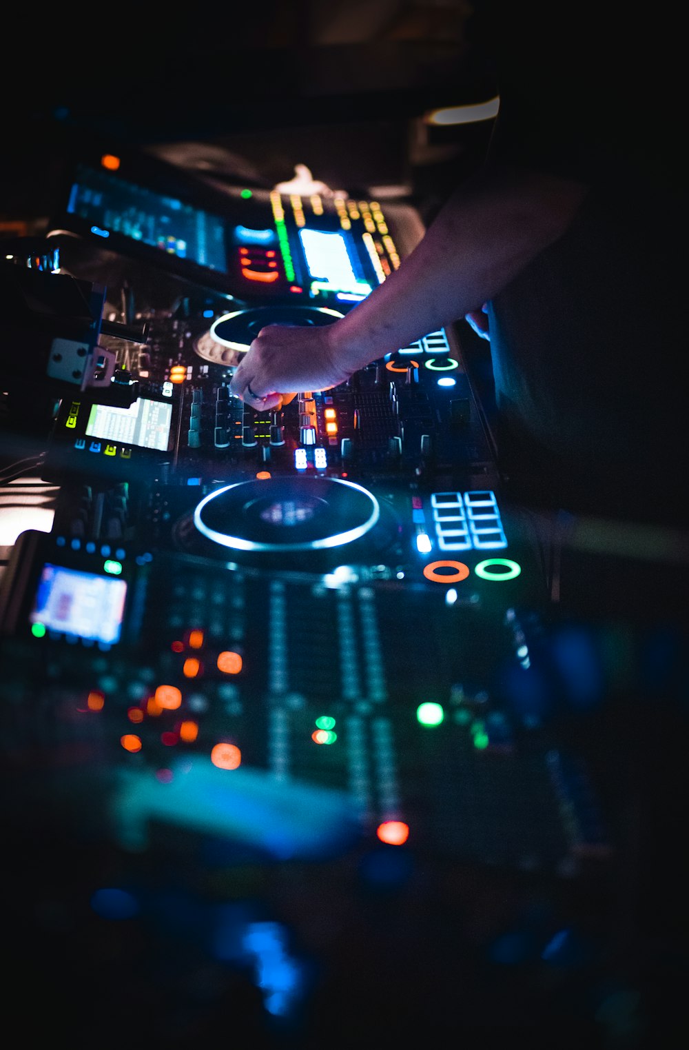 a hand holding a device above a dj turntable