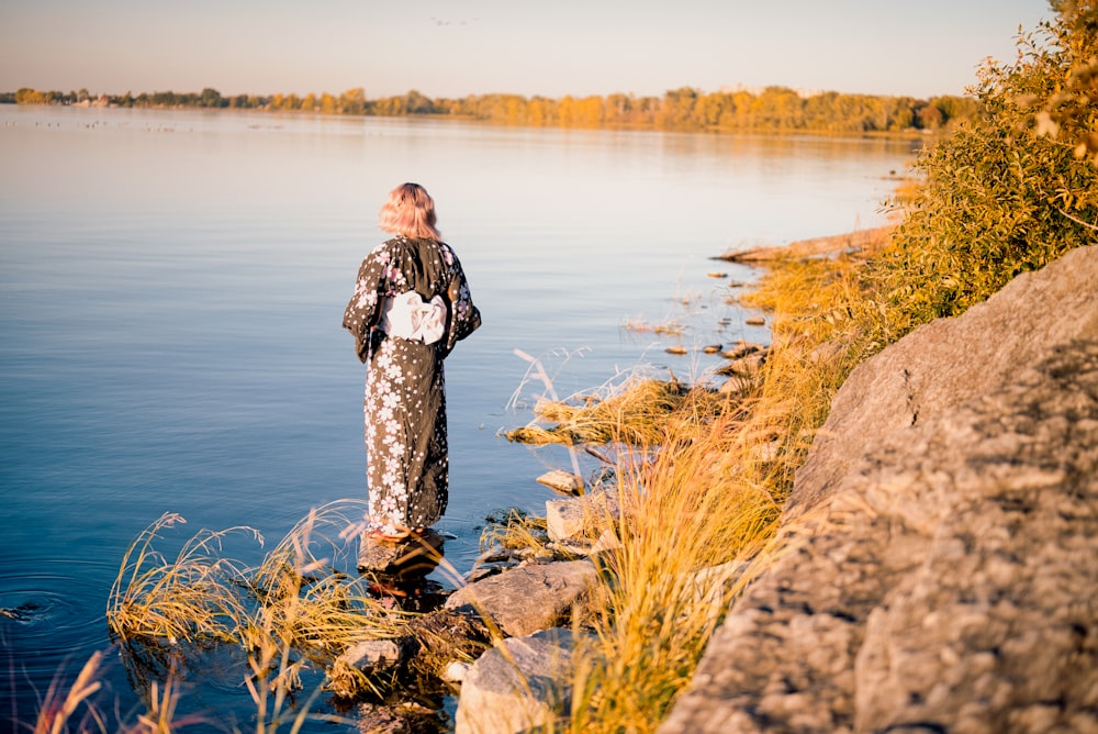 a man standing on a rock in a body of water