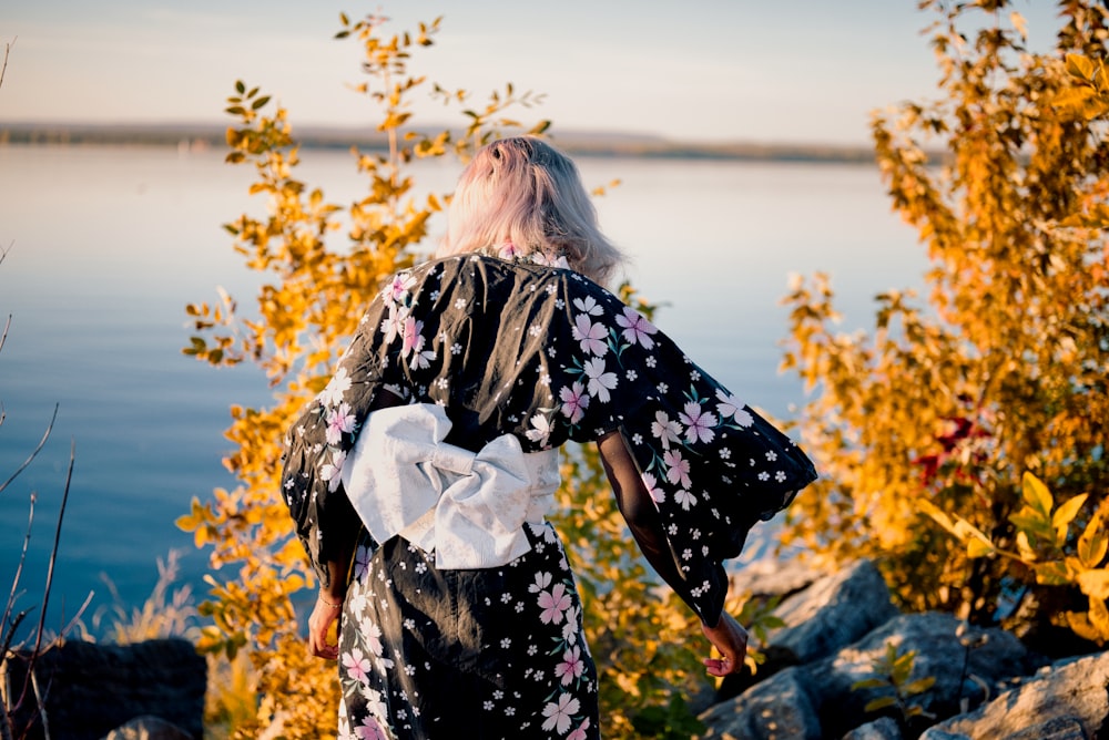 a person standing on a rock looking at the water