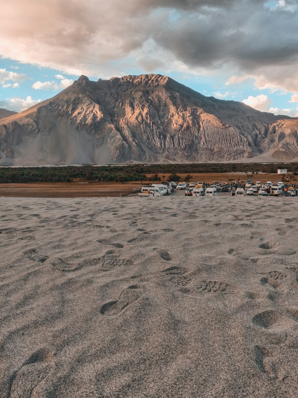 a group of boats parked on a beach in front of a mountain