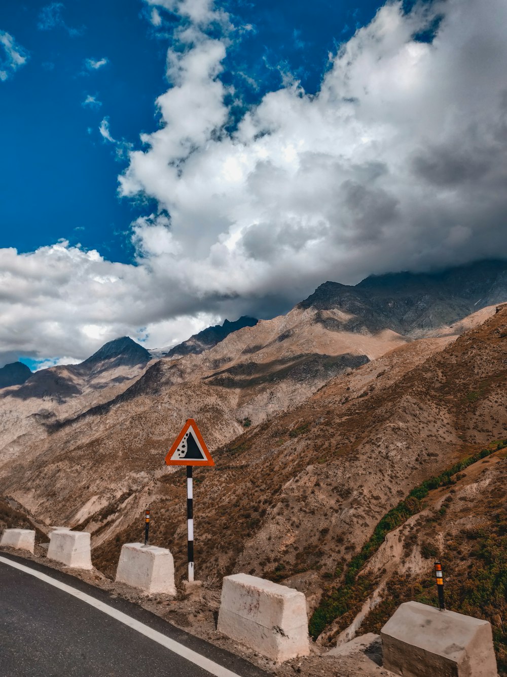 a road with a sign on it and mountains in the background