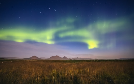 A serene Icelandic landscape under vibrant northern lights with ancient runes subtly carved into nearby stones.