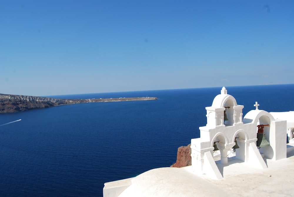 a white building on a cliff above the ocean