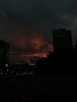 A moody analog photo of a city street at dusk, with teal and orange hues.