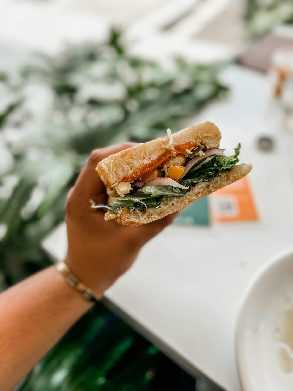 a hand holding a sandwich