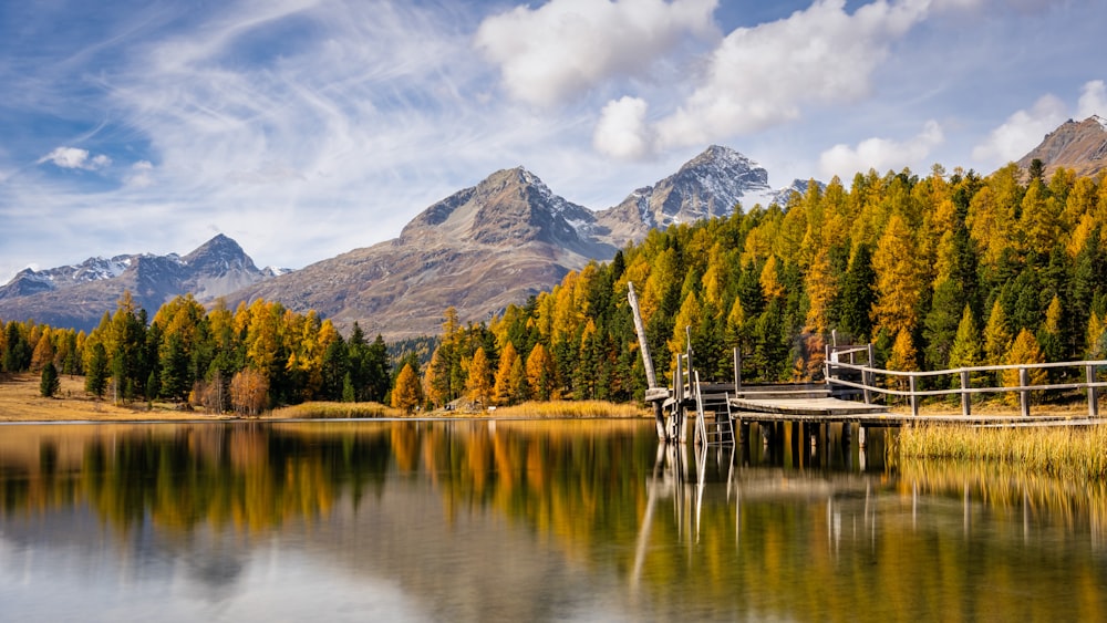 a lake with trees and mountains in the background