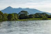 a body of water with trees and mountains in the background
