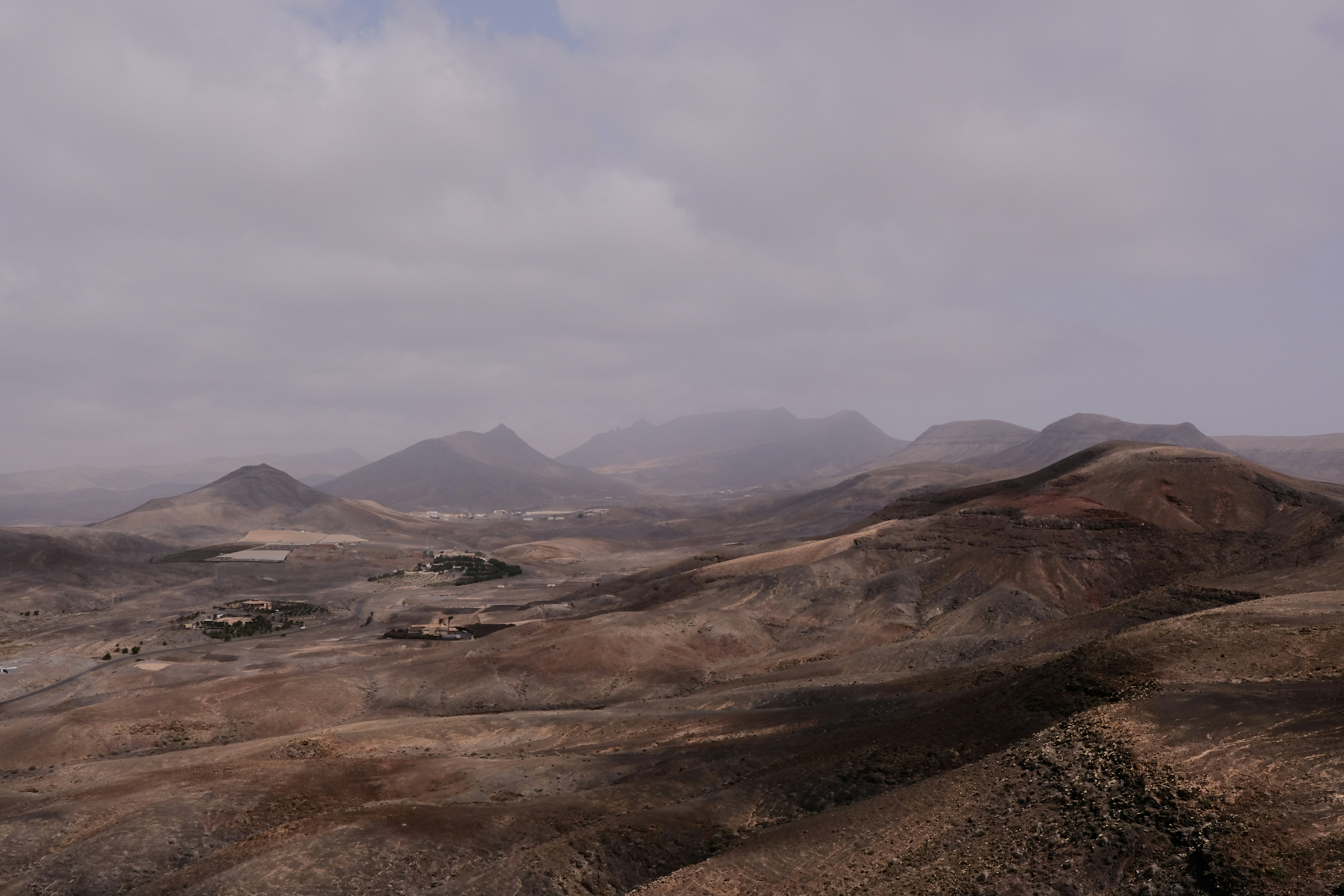 a landscape with hills and a body of water in the distance
