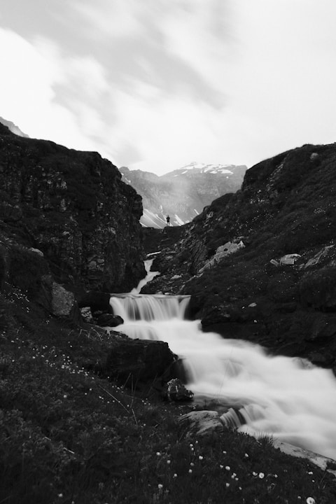 a river running through a valley between mountains