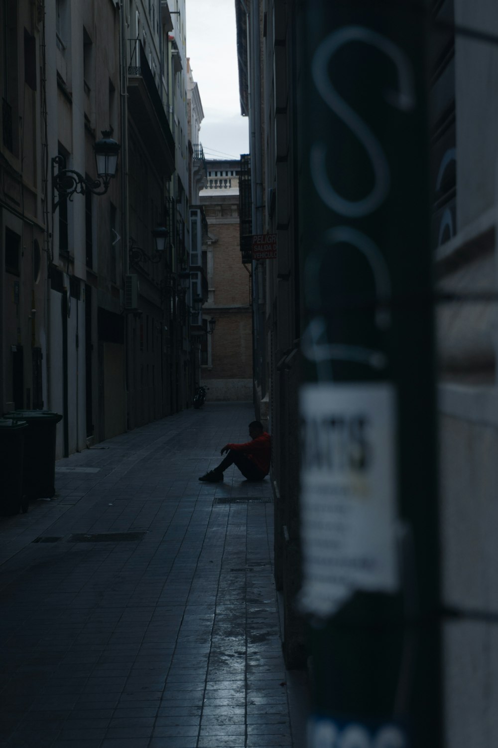 a person sitting on a sidewalk