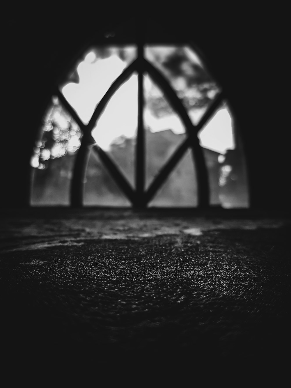 a black and white photo of a house with a large window