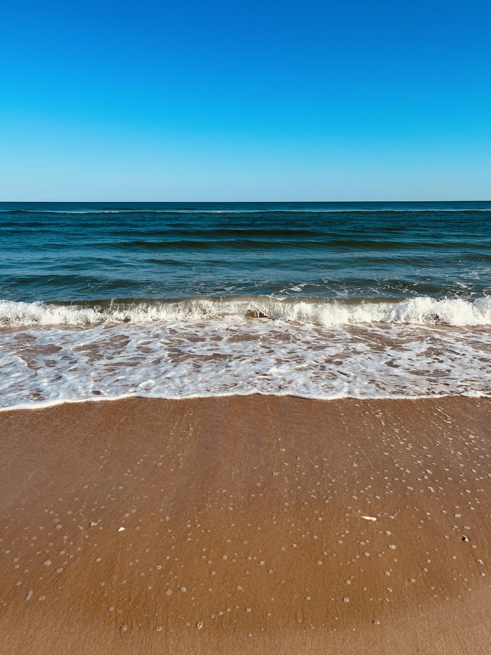 uma praia de areia com ondas
