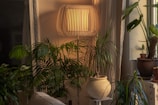 A cozy living room softly lit by a plant-based PLA lamp shaped like a blooming flower.