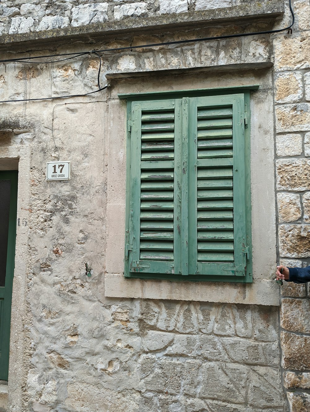 a green window on a stone building