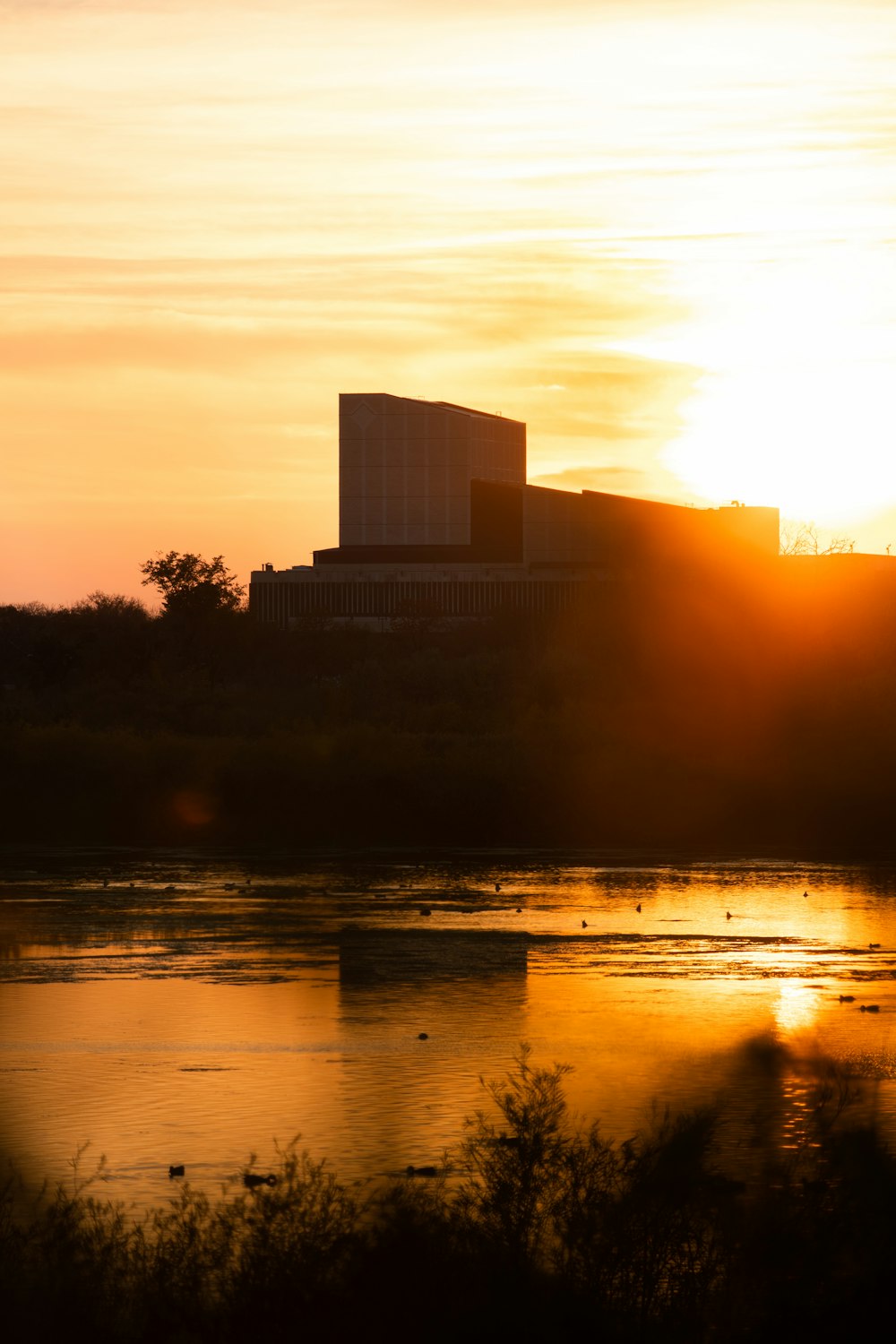 a building on a hill by a body of water