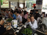 Busy restaurant scene with happy customers enjoying diverse dishes.