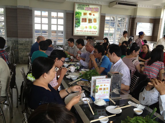 Happy diners sharing laughter and enjoying their meals in the intimate restaurant setting.