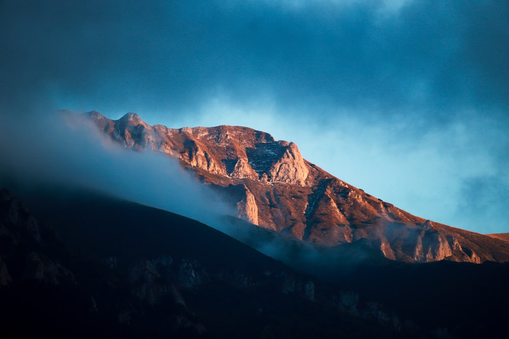 a mountain with clouds in the sky