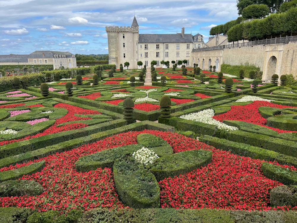 a garden with flowers and Château de Villandry in the background