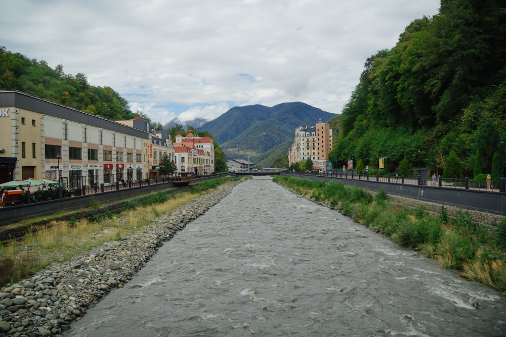 a river with a stone path and buildings on either side of it