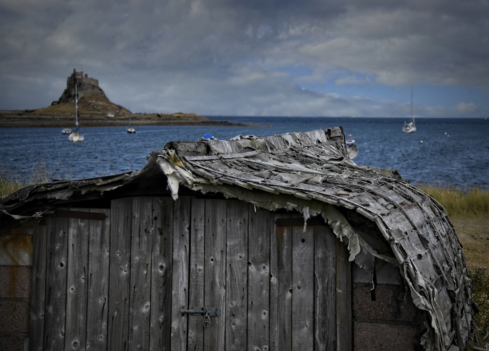 a wooden building with a boat in the water