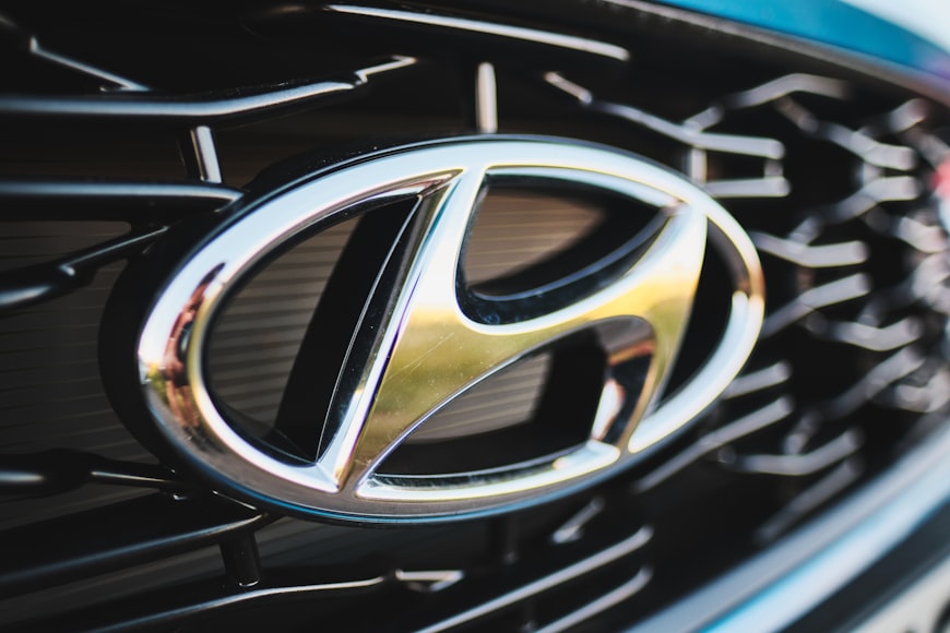 The silver Hyundai logo on the front of a car zoomed in