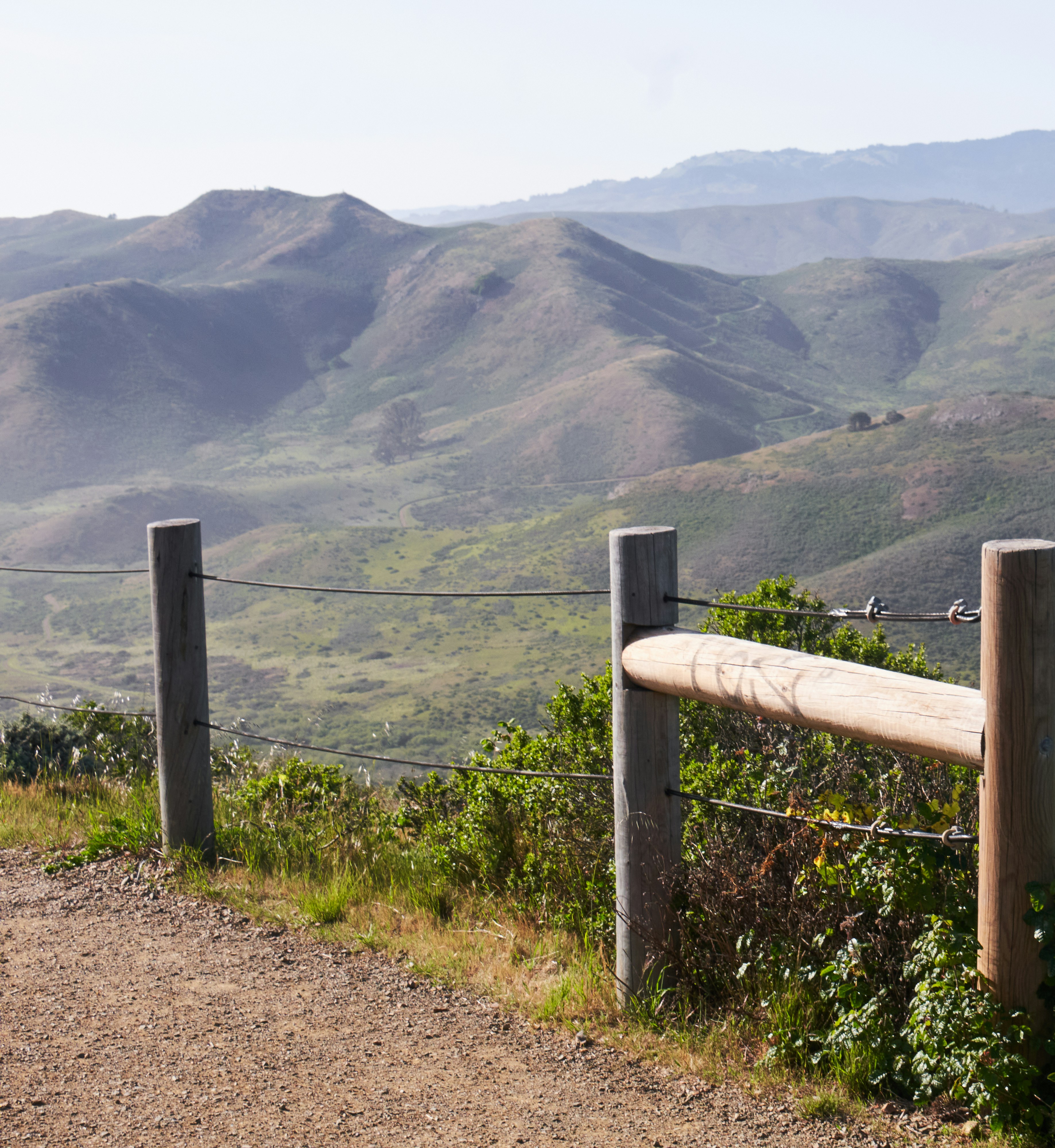 A fence in front of a green valley