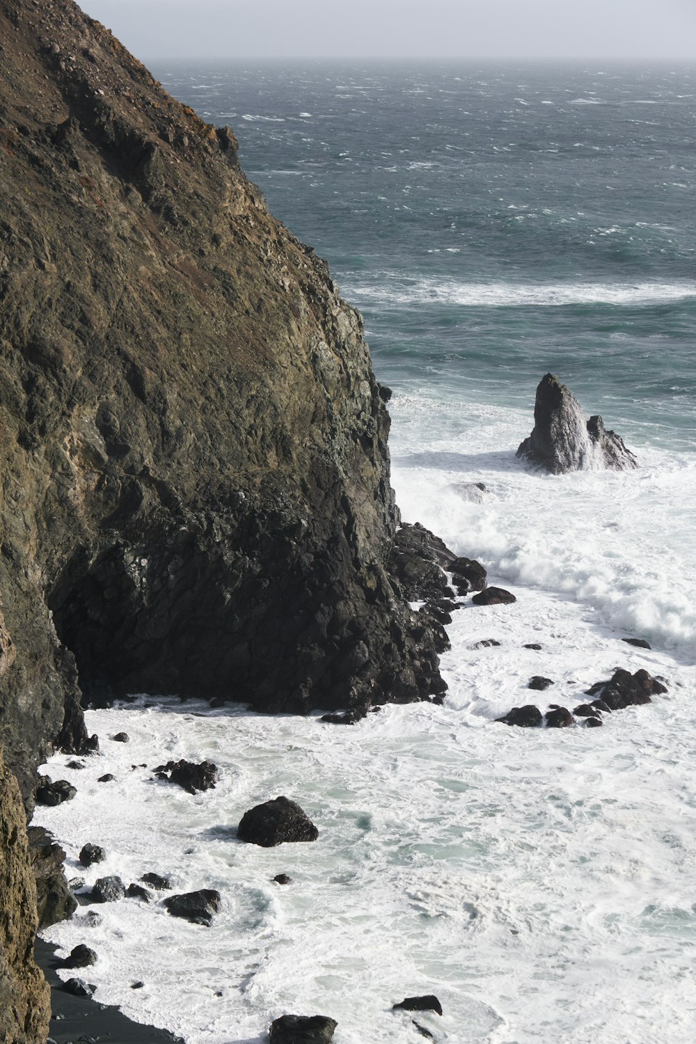 a rocky beach with waves crashing against it