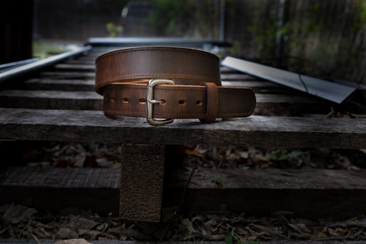 a brown leather purse on a wooden bench