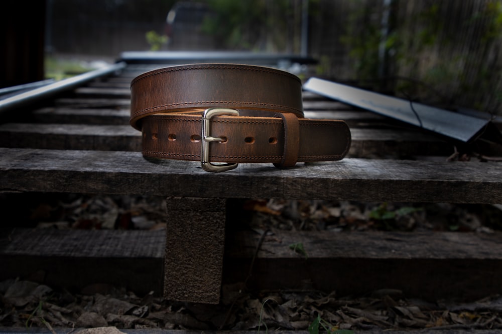 a brown leather purse on a wooden bench