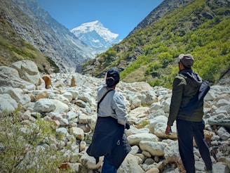 a group of people walking on a rocky path in the mountains