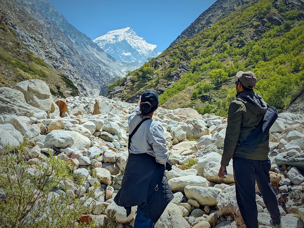 a group of people walking on a rocky path in the mountains