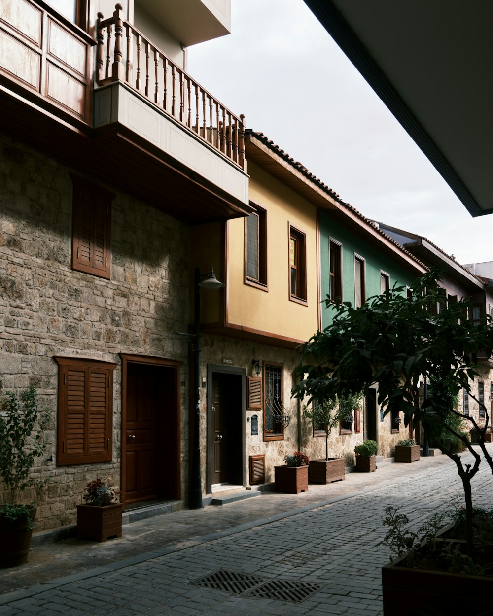 a stone street with a stone building and trees on both sides