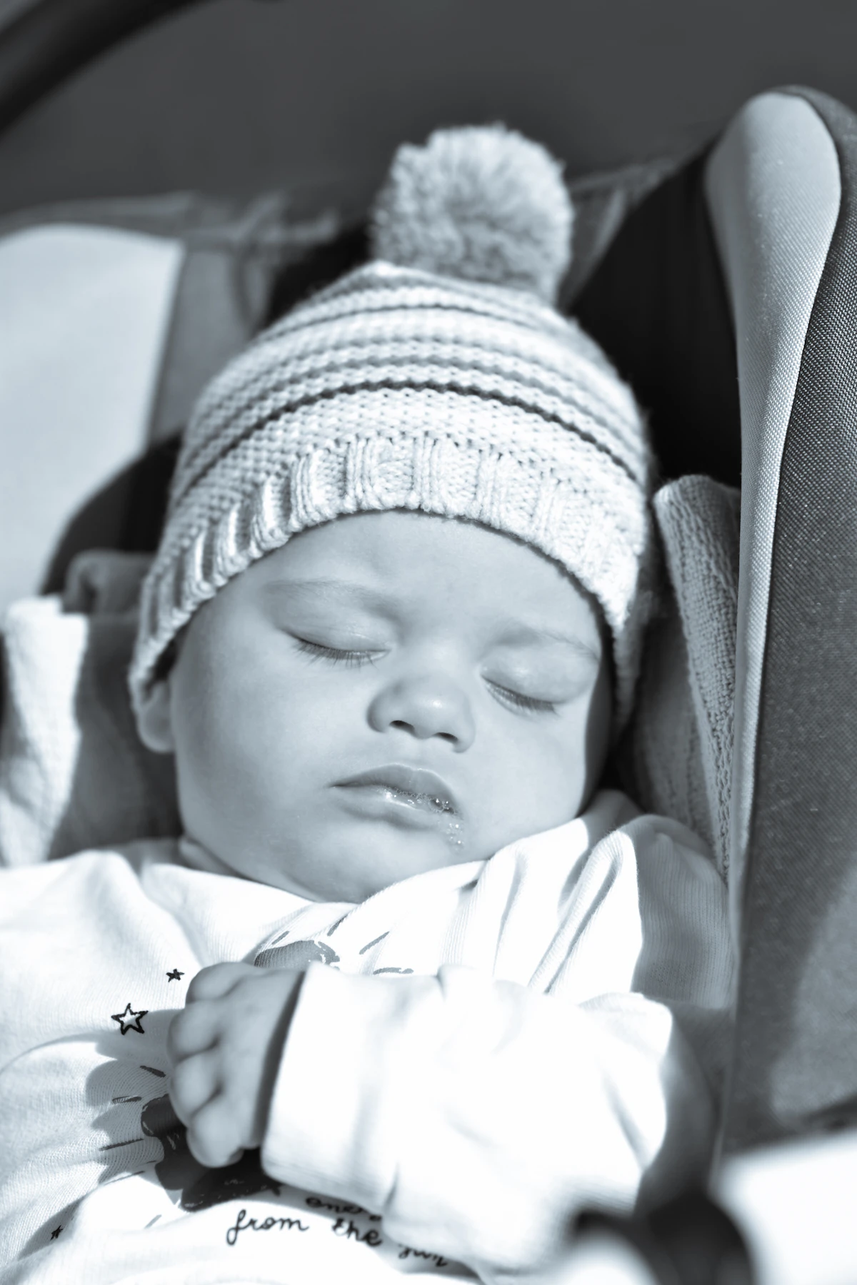 Newborn baby sleeping in a compact infant car seat with carry handle