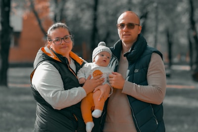 a man and woman holding a baby