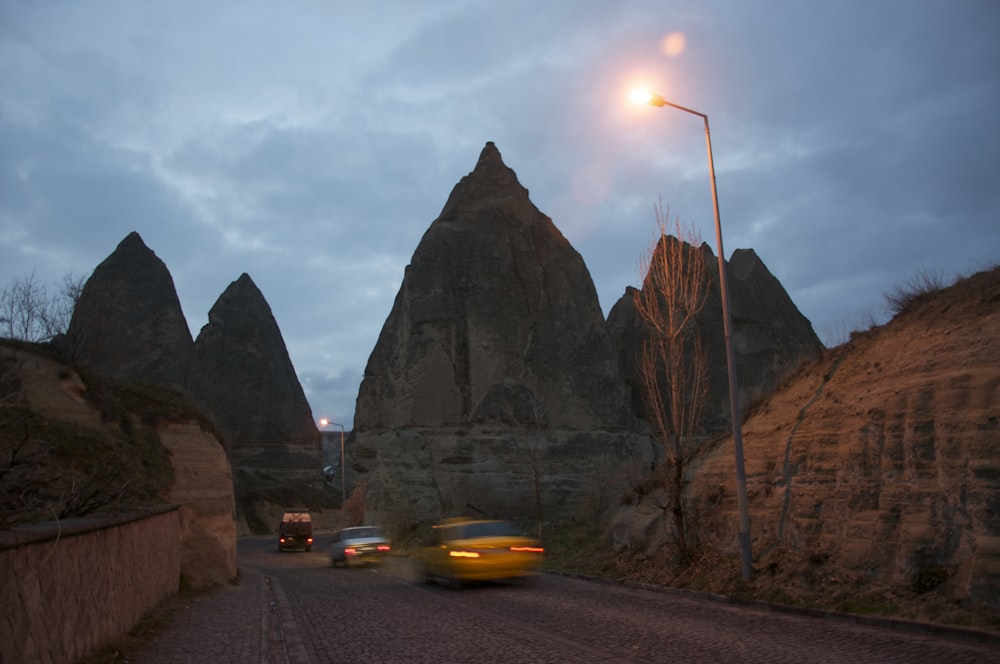 cars driving on a road between large rocks