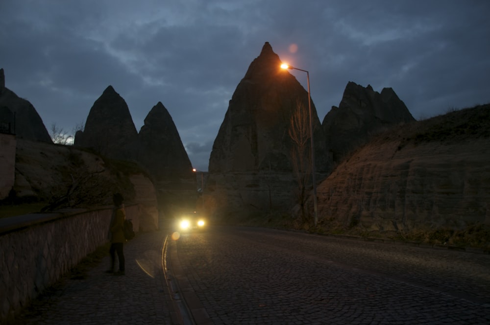 a person standing on a road with a light on the side