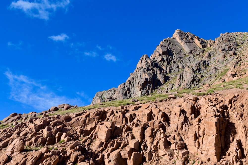 a rocky mountain with a blue sky