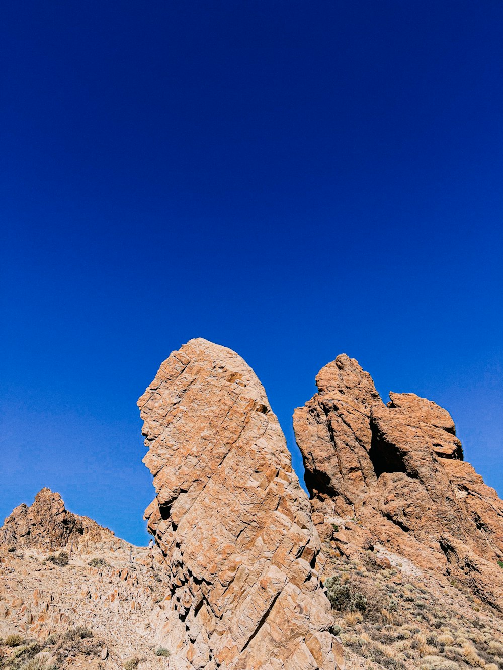 a rocky mountain with a blue sky