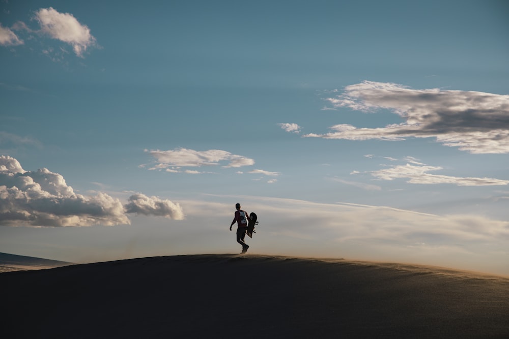 a person and a dog walking on a hill