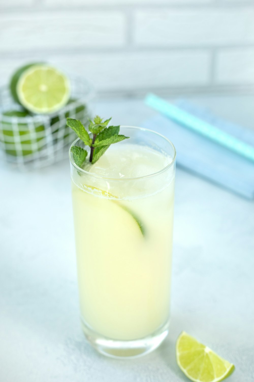 a glass of lemonade with a lime wedge and a lemon slice