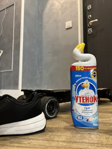 Close-up of molecular odor neutralizers being applied to a pet accident spot on hardwood floor.