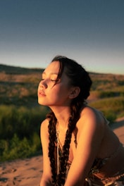 Side view of long jumbo braids flowing over the shoulder in a sunny outdoor setting.