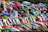 A group of motocross riders lined up, each wearing colorful helmets and gear. Their motorcycles are vibrant and varied in design, highlighting the diversity of the sport. The scene is dynamic, full of energy and anticipation.