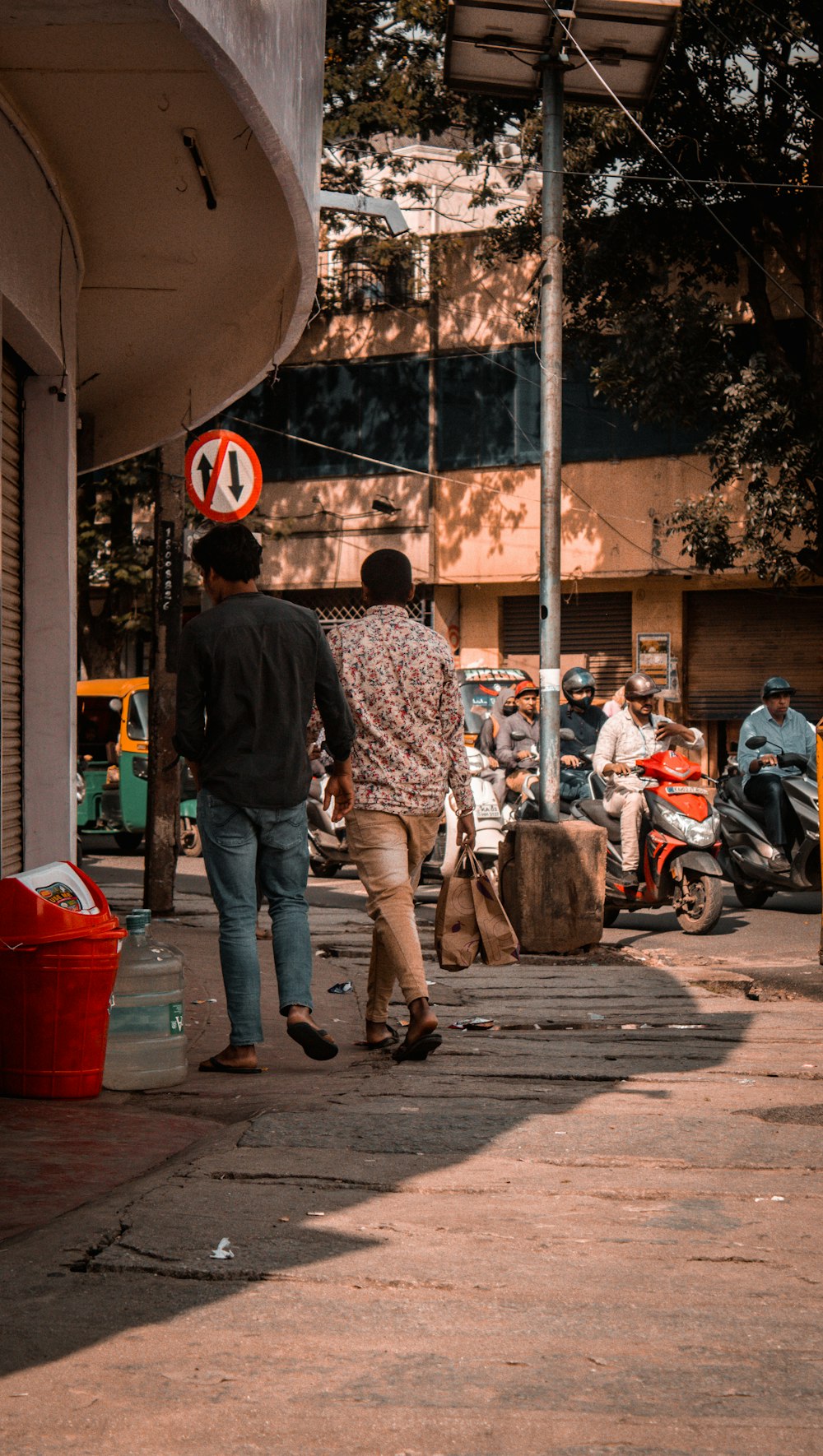 a couple of men walking down a sidewalk