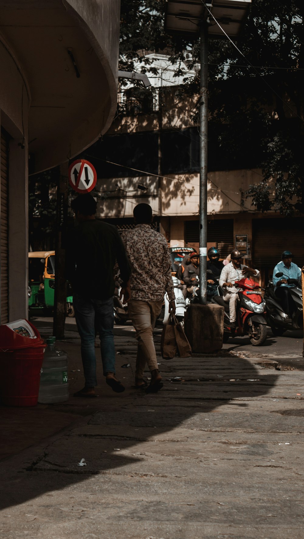 a couple of people walk down a sidewalk