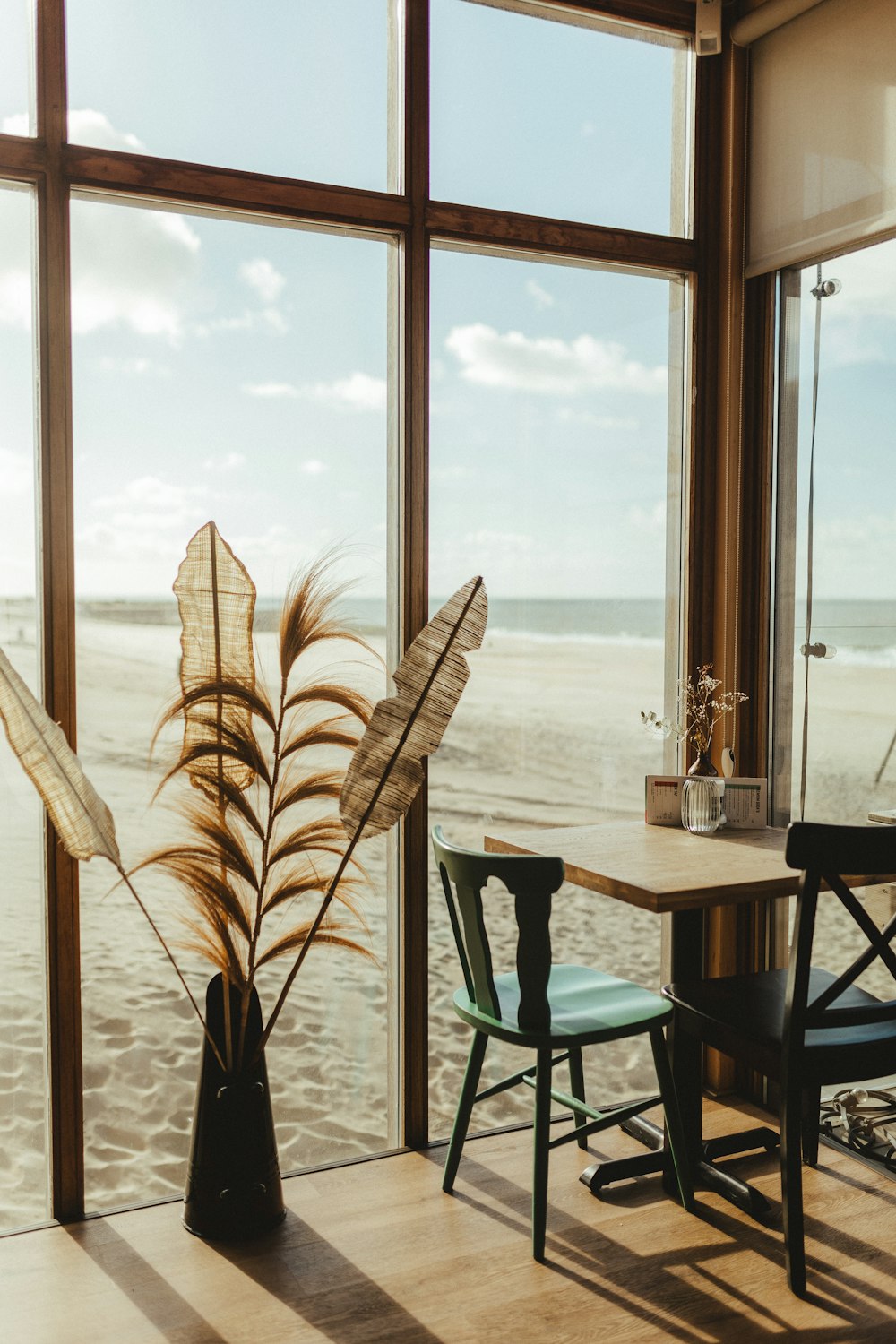 a table and chairs in front of a window overlooking the ocean